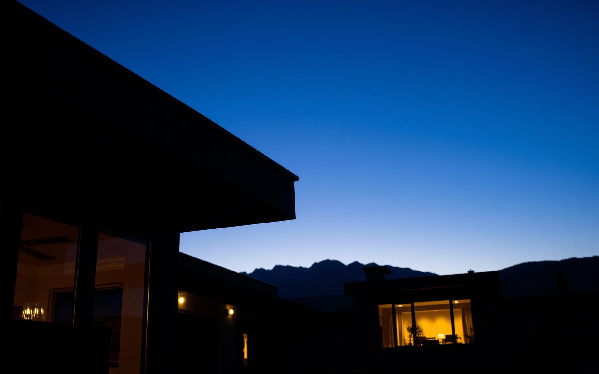 Modern Utah home protected by Sentinel Peak Security at dusk with the Wasatch mountains behind it